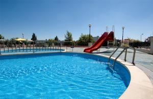 una piscina con un tobogán rojo. en Hotel Eurosol Alcanena, en Alcanena