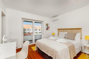 una camera bianca con un letto e una finestra di Haus Abel - pool, parking and garden in the heart of Lisbon a Lisbona