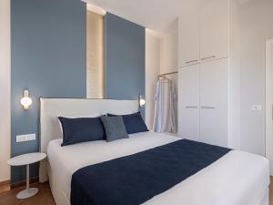 a bedroom with a large bed with blue and white at Elena Seafront Luxury Apartments in Almirida