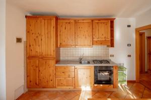 una cucina con armadi in legno e piano cottura di Mountain Bliss Retreat - 20min from Cortina a Borca di Cadore