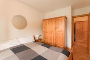 una camera con letto e armadio in legno di Mountain Bliss Retreat - 20min from Cortina a Borca di Cadore