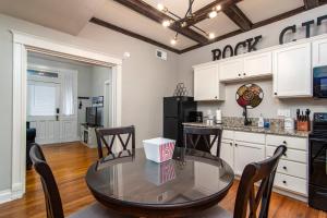 uma cozinha com uma mesa de vidro e cadeiras num quarto em Charming New Orleans-Style Apartment with Gated Courtyard! em Little Rock