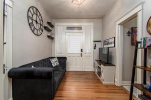 uma sala de estar com um sofá preto e uma televisão em Charming New Orleans-Style Apartment with Gated Courtyard! em Little Rock