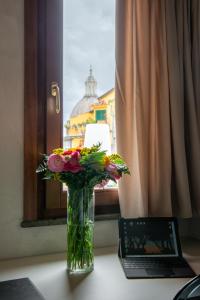 a vase of flowers sitting on a table next to a laptop at Residenza Leutari in Rome