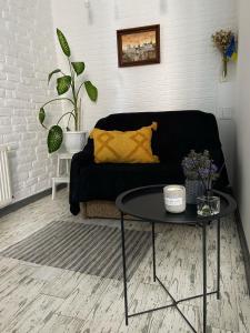 a living room with a black couch and a table at Квартира у Старому місті in Kamianets-Podilskyi