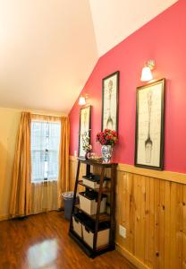 ein Zimmer mit roten Wänden und einem Regal mit Büchern in der Unterkunft Hinckleys Dreamwood Cottages in Bar Harbor