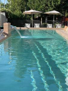 a swimming pool with a water fountain at Corinthian Village in Vrahati