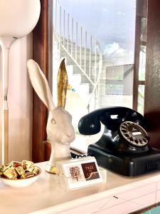 un lapin assis sur un comptoir avec téléphone dans l'établissement Tree of Life Art Hotel, à Agia Marina