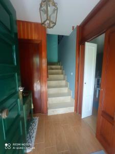 a hallway with a staircase and a door and a stair case at En el camino in Santiso