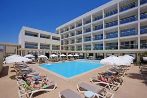 un hotel con piscina con sedie e ombrelloni di Nelia Gardens a Ayia Napa