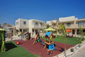 un parco giochi di fronte a un condominio con parco giochi di Nelia Gardens a Ayia Napa