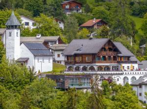 une grande maison et une tour dans un village dans l'établissement FidazerHof, à Flims