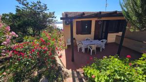 a patio with a table and chairs on a house at LA TERRAZZA SUL MARE - panoramic cottage overlooking sea and Caprera island in a quiet residential area - 150 mt from the sea in La Maddalena