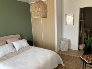 1 dormitorio con 1 cama blanca y 1 lámpara en RESIDENCE SERVICES MONTANA Paris Clichy, en Clichy