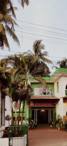 a building with palm trees in front of it at Hotel Bonanza in Baga