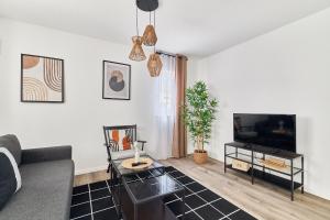 ein Wohnzimmer mit einem Sofa und einem TV in der Unterkunft Elegantes 2 Zimmer Apartment Neubau Ruhige Lage in Mannheim