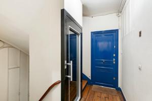 porta blu in un corridoio con pavimento in legno di GuestReady - Apt fonctionnel situé dansl e 15ème a Parigi