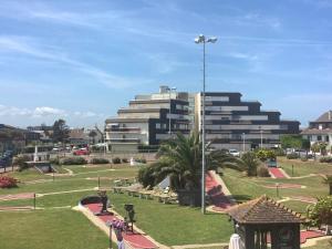 een groot gebouw met een park ervoor bij "O'Dbark" - duplex 2 étoiles - à 100m de la plage in Courseulles-sur-Mer