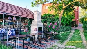 a garden with a table and chairs and flowers at Penzión Vilka Podhájčanka in Podhájska