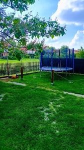 a blue playground in a yard next to a fence at Penzión Vilka Podhájčanka in Podhájska