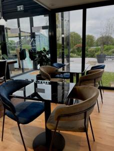 a group of chairs and tables in a room with windows at Kyriad Deauville - St Arnoult in Deauville