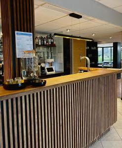 a bar in a restaurant with a counter top at Kyriad Deauville - St Arnoult in Deauville