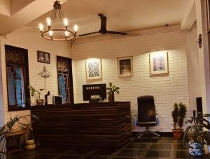 a lobby with a desk and a chair and a chandelier at Hotel Bonanza in Baga