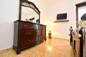 a bedroom with a dresser and a mirror at B&B Family in Torre del Greco