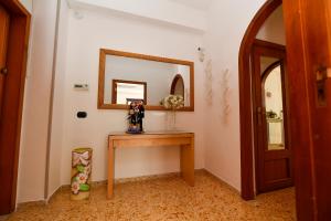 a room with a table and a mirror on the wall at B&B Family in Torre del Greco