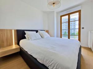 Tempat tidur dalam kamar di Sublime appartement 4 étoiles neuf T3 àPuteaux 61m2 proche La Défense, 10m2 de terrasse avec magnifique vue