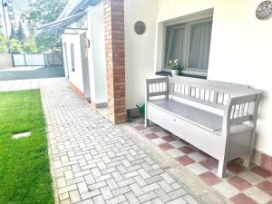 a bench sitting on the side of a house at Tündérkert Apartman in Gyula