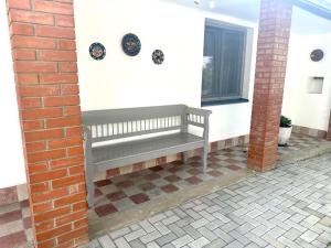 a bench on the side of a house with a window at Tündérkert Apartman in Gyula