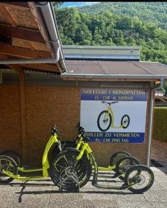 een gele fiets geparkeerd voor een gebouw bij Camping Alex in Cadenazzo