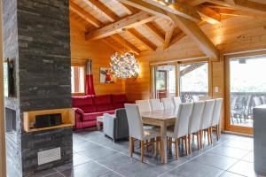 een eetkamer met een tafel en stoelen en een rode bank bij Les Chalets d'Adelphine & SPA in Les Gets