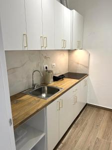 a kitchen with white cabinets and a sink at Vila Beqja in Durrës