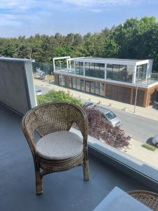 einen Korbstuhl auf dem Balkon in der Unterkunft AJ Holiday - Władysławowo in Władysławowo