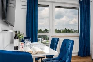 ein Esszimmer mit einem Tisch und blauen Stühlen in der Unterkunft Warsaw Modern Stay in Warschau