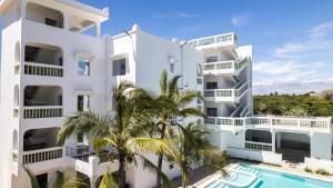 un immeuble d'appartements avec piscine et palmiers dans l'établissement Avana Resort Watamu, à Watamu