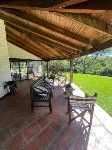 un patio con panche sotto un tetto in legno di Casita de campo en Altos a San Lorenzo