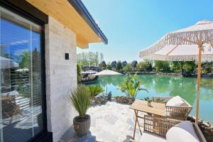 a patio with a table and chairs and a pool at Kompleksi Turistik DEA in Shkodër