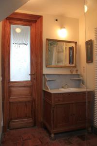 a bathroom with a sink and a mirror and a door at La Passiflore B&B in Bossière