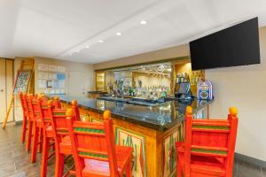 a bar with a row of orange chairs around it at Best Western Plus Rio Grande Inn in Albuquerque