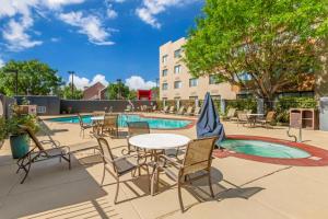 a patio with tables and chairs next to a pool at Best Western Plus Rio Grande Inn in Albuquerque