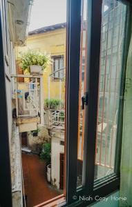 ein offenes Fenster mit Blick auf einen Balkon in der Unterkunft Niah Cozy Home - Train Street in Hanoi