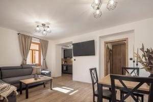 een woonkamer met een bank en een tafel bij Apartmán Oliva in Horní Planá