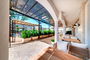 um pátio exterior com bancos e vasos de plantas em Avenue Deluxe Hotel em Sunny Beach