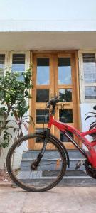 una bicicleta roja estacionada frente a un edificio en Swanky Sojourns Cosy Home Stay, en Kolhapur