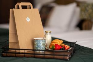 bandeja con una bolsa y un plato de comida y fruta en Stonehenge Courtyard, en Amesbury