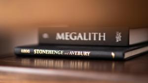 dos libros apilados uno encima del otro en una mesa en Stonehenge Courtyard, en Amesbury