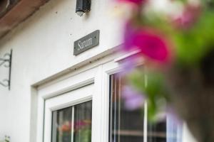 una señal en el lado de un edificio con flores en Stonehenge Courtyard, en Amesbury